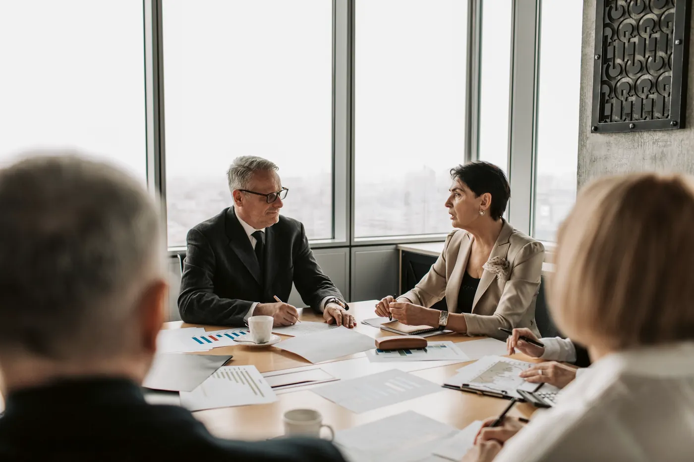 Colleagues around a boardroom table reviewing documents together.