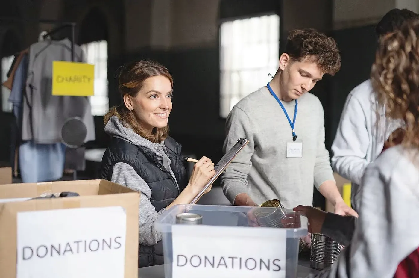 Volunteers recording and sorting donations into labelled boxes.