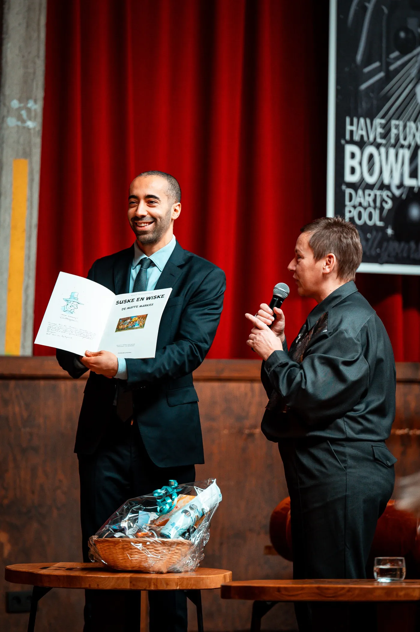 A presenter handing an award to a recipient on stage.