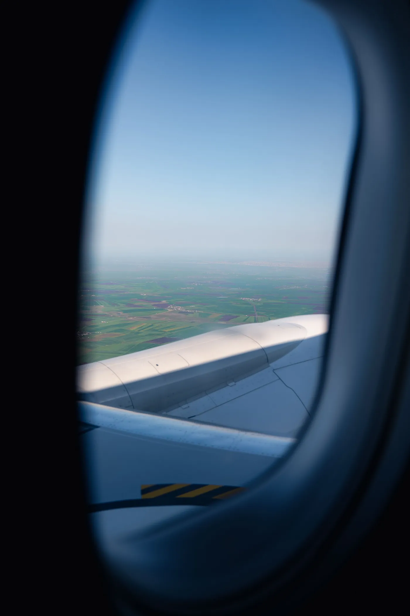View of an aircraft wing through a cabin window.