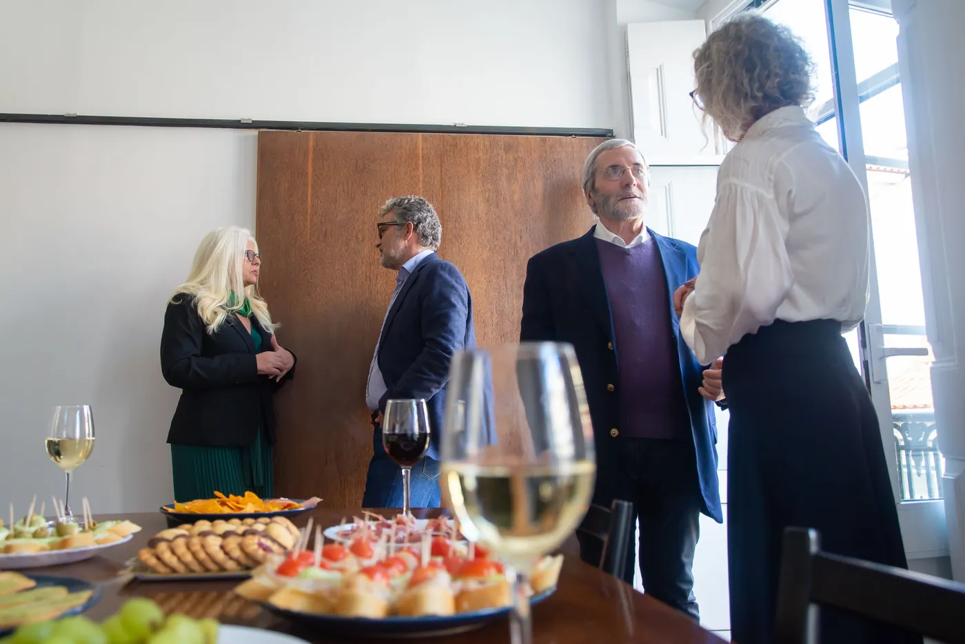 Professionals in conversation at an evening networking reception.