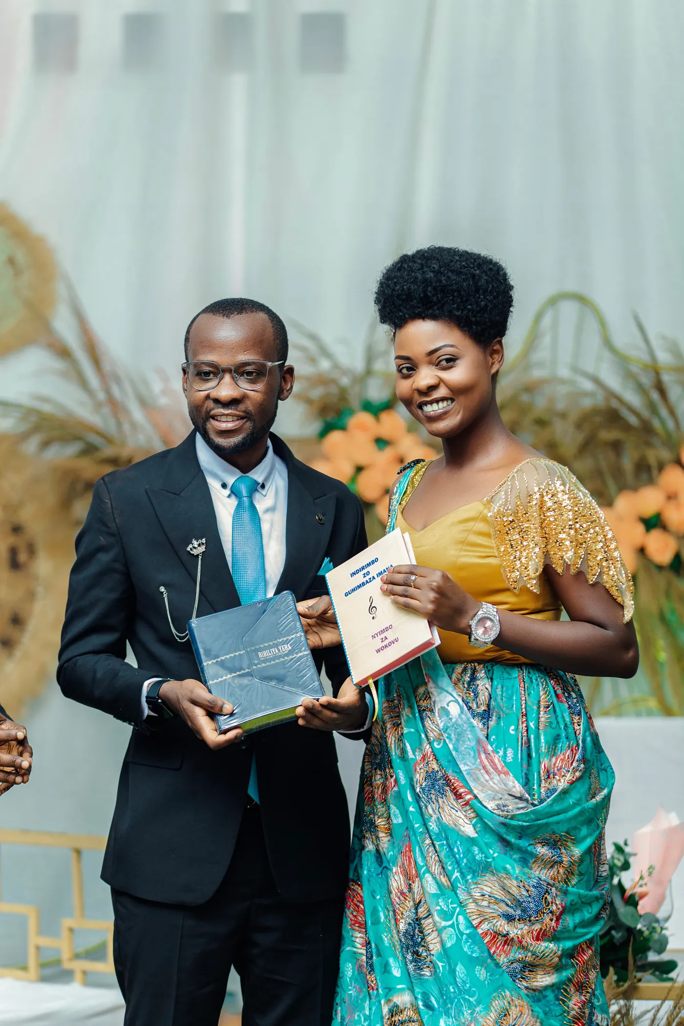 Two people smiling while holding a certificate at a ceremony.