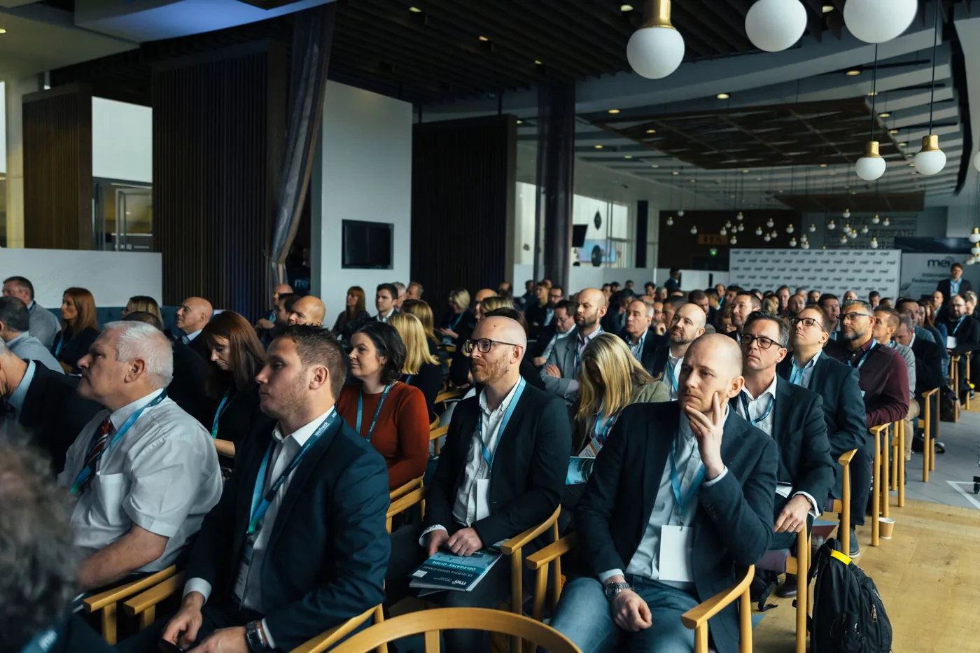 Professionals seated in a conference hall during a seminar.